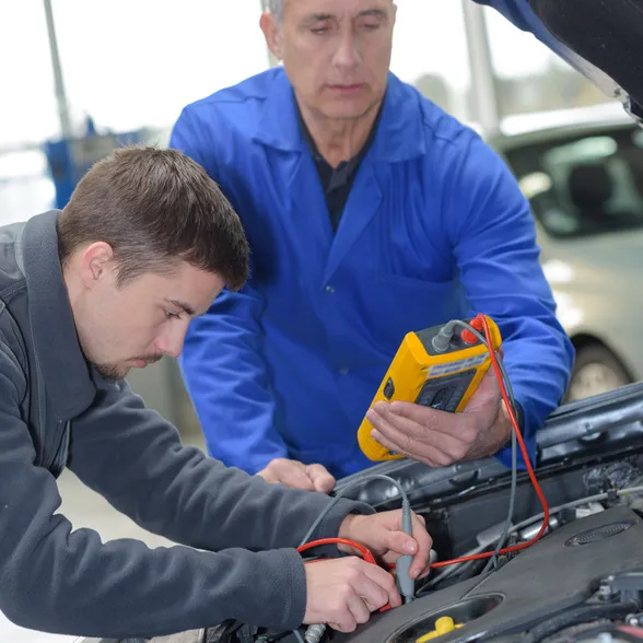 mechanic and apprentice working on car