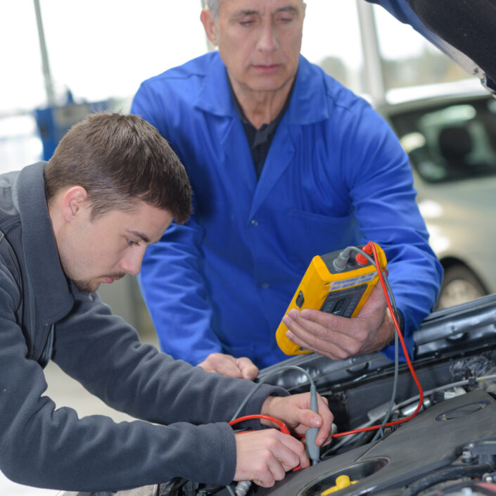 mechanic and apprentice working on car